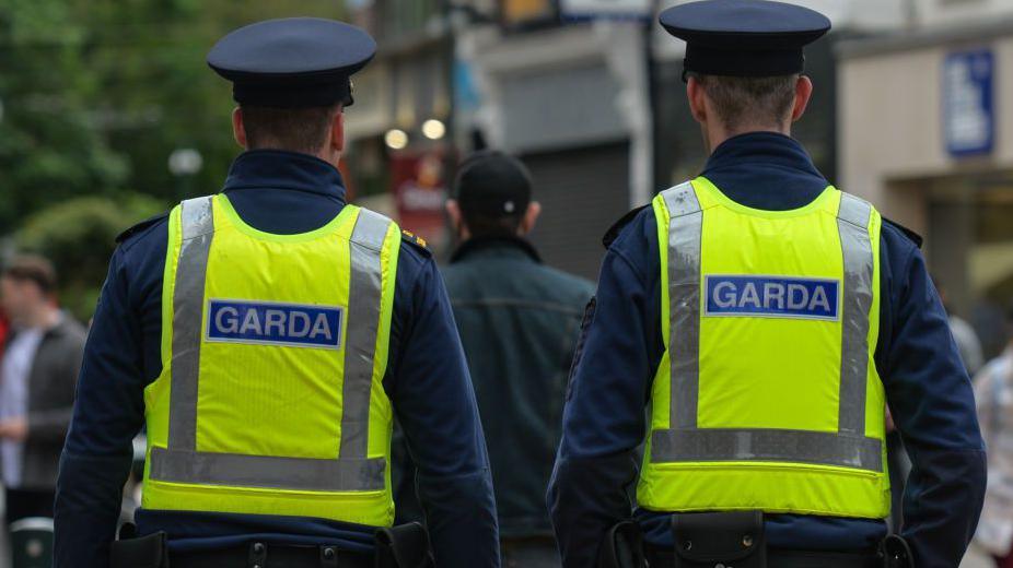 Garda officers walk n the street 