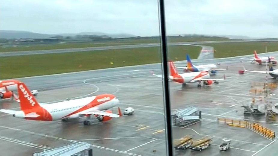 Planes on the tarmac at Bristol Airport. Several white and orange EasyJet planes can be seen as well as airport equipment.