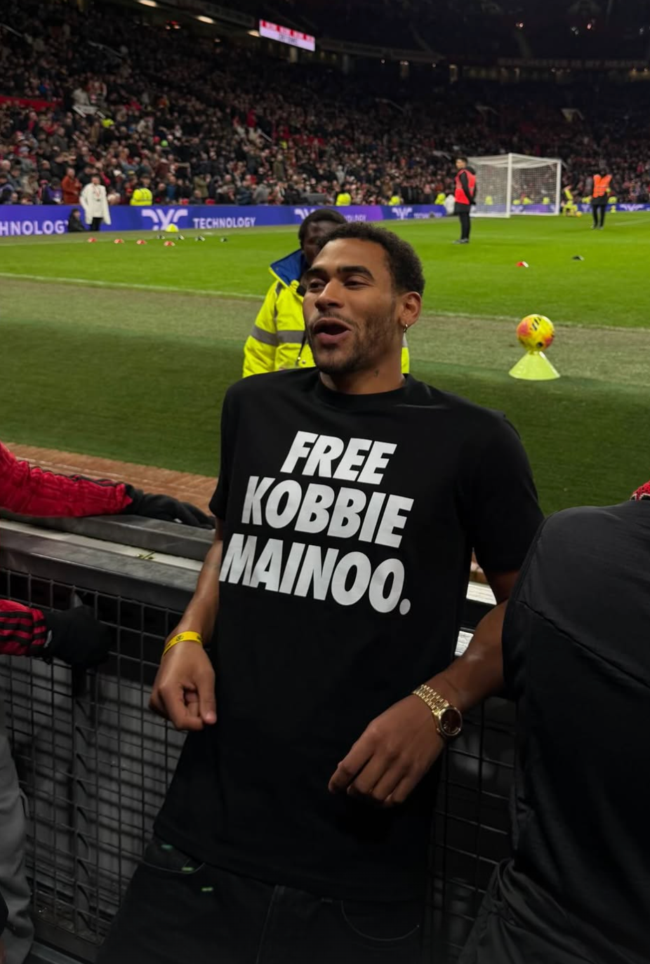 Jordan Mainoo-Hames wears a t-shirt at Old Trafford that reads 'Free Kobbie Mainoo'
