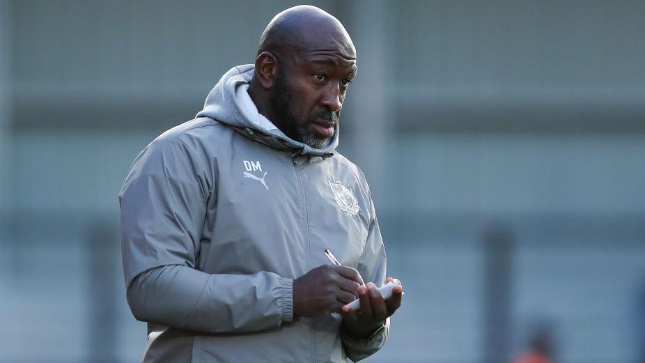 Darren Moore makes some notes during a Port Vale match