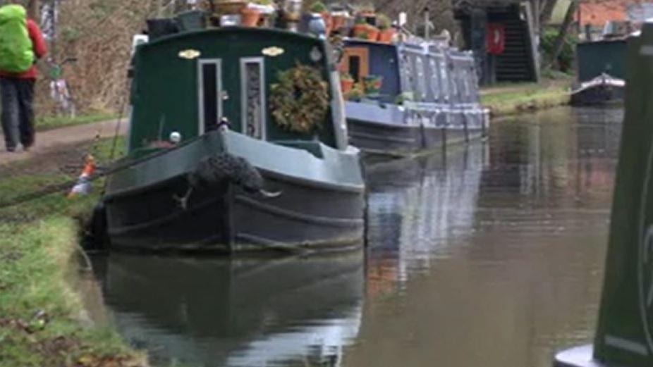 Narrow boats moored on the canal on an overcast day.