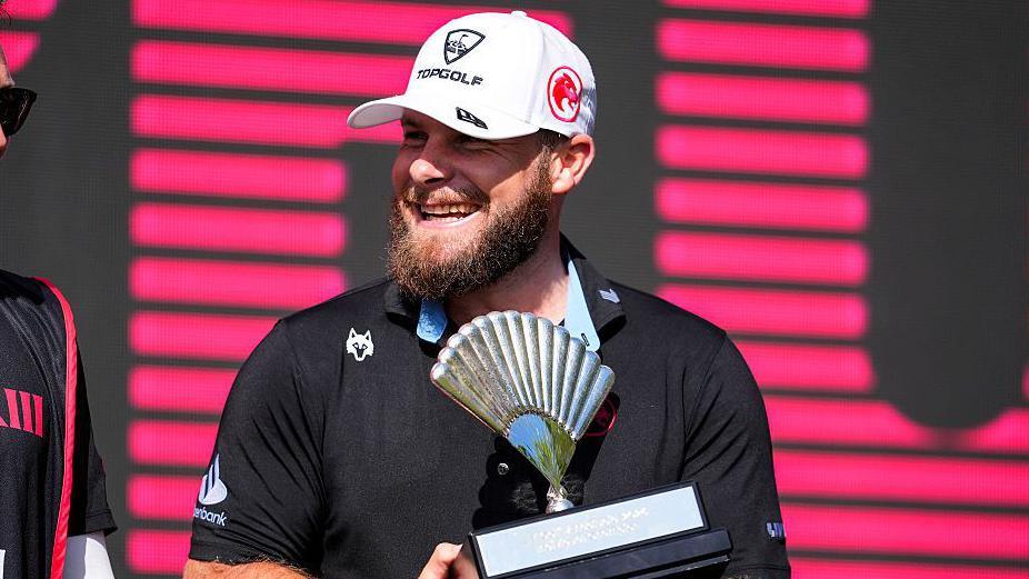 Tyrrell Hatton smiles as he holds the trophy for winning in Andalucia