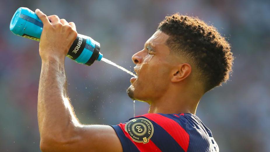 United States defender Miles Robinson takes a drink during a break on a hot day in the second half of a Concacaf Gold Cup match between Canada and the United States in July 2021