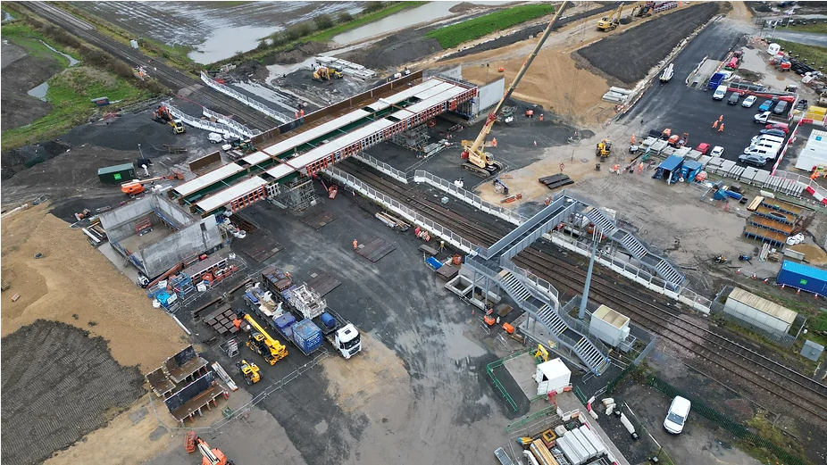 An aerial view of a bridge being put in place over a railway line 