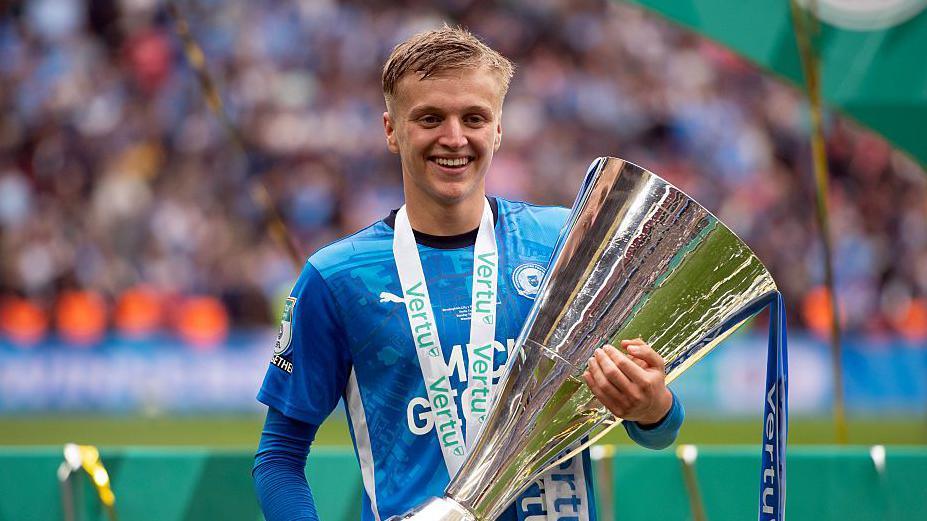 Harley Mills holding the EFL Trophy at Wembley