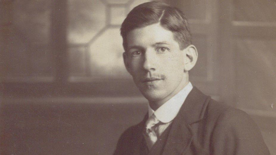 Gunner Lightfoot seen in a black and white photograph. He is wearing a suit and looking at the camera