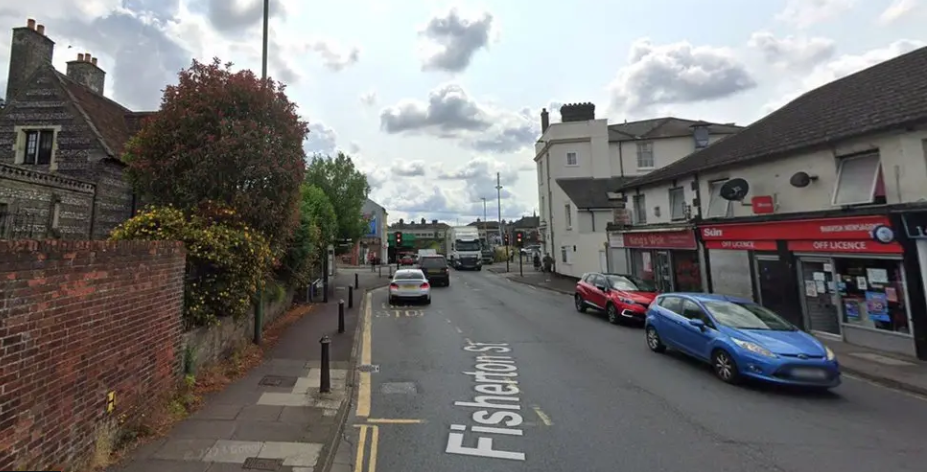 A view of Fisherton Street with shops and parked cars on a cloudy day