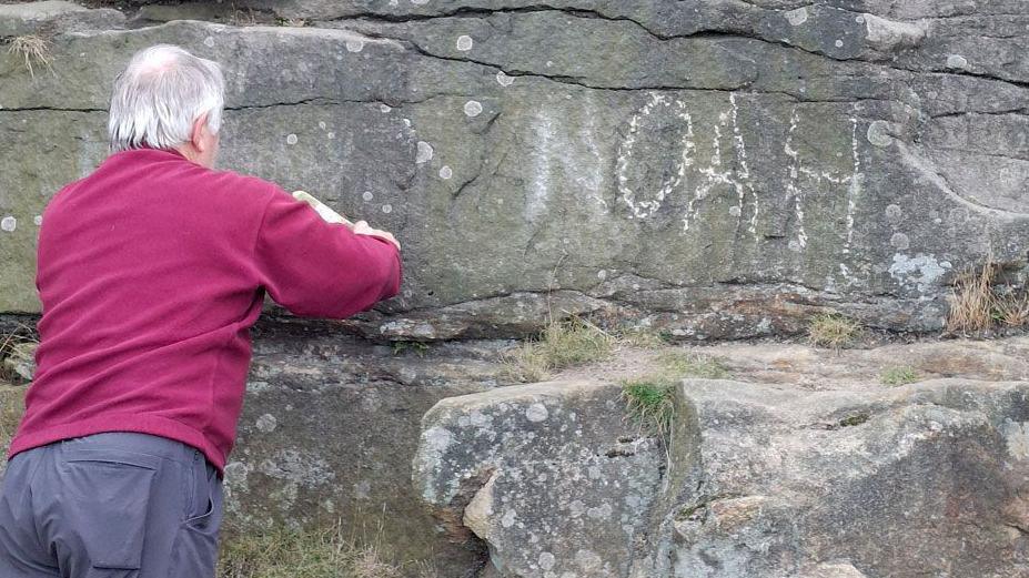 The name Noah being removed from the cave