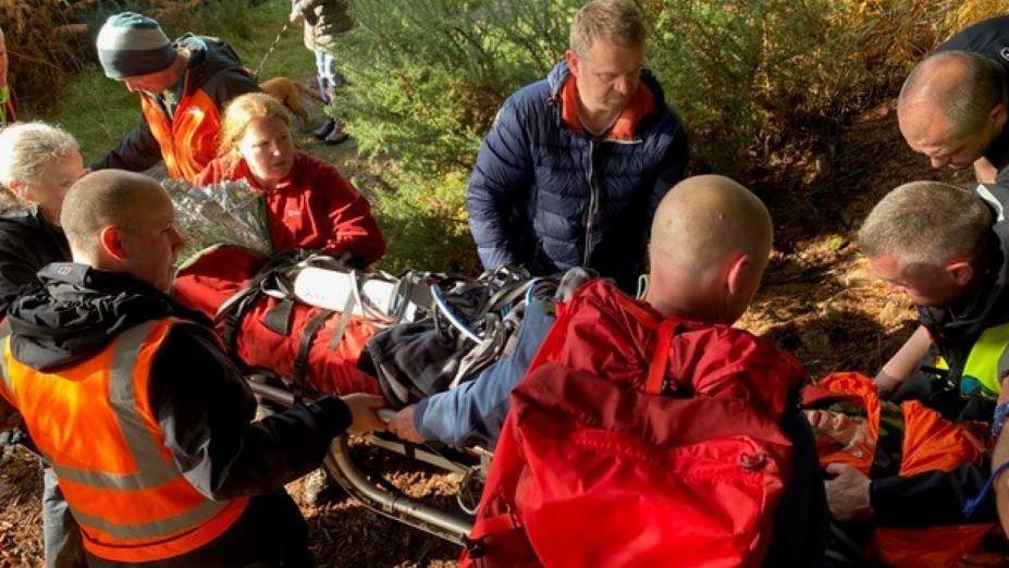 Matthew in a stretcher after his accident