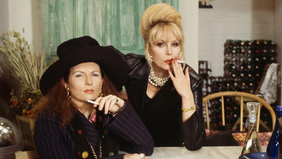 Jennifer Saunders (left) and Joanna Lumley smoking cigarettes on the set of the television sitcom 'Absolutely Fabulous', 21 May 1993