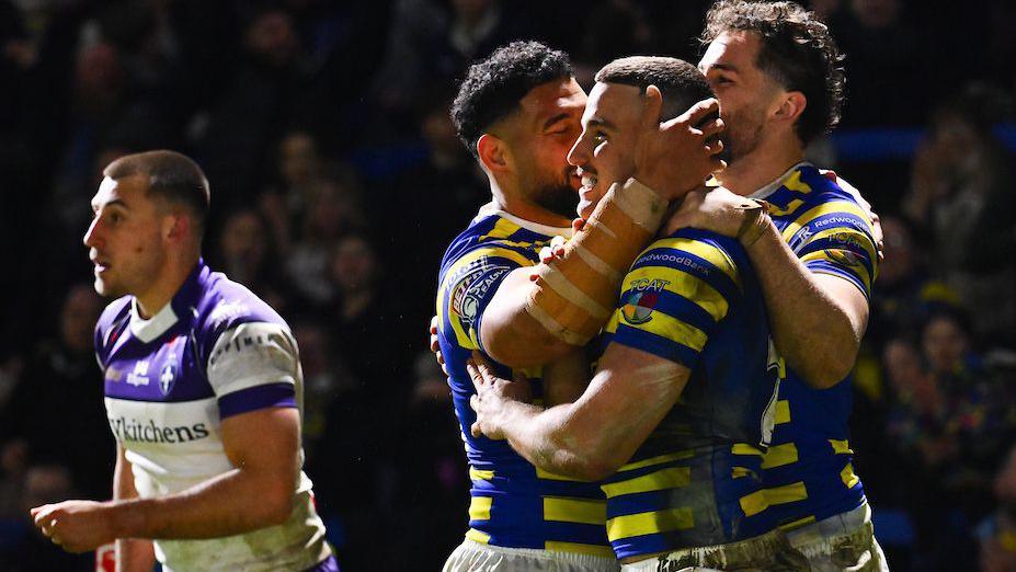 Warrington Wolves player Josh Smith is congratulated by team-mates for scoring a try against Wakefield Trinity