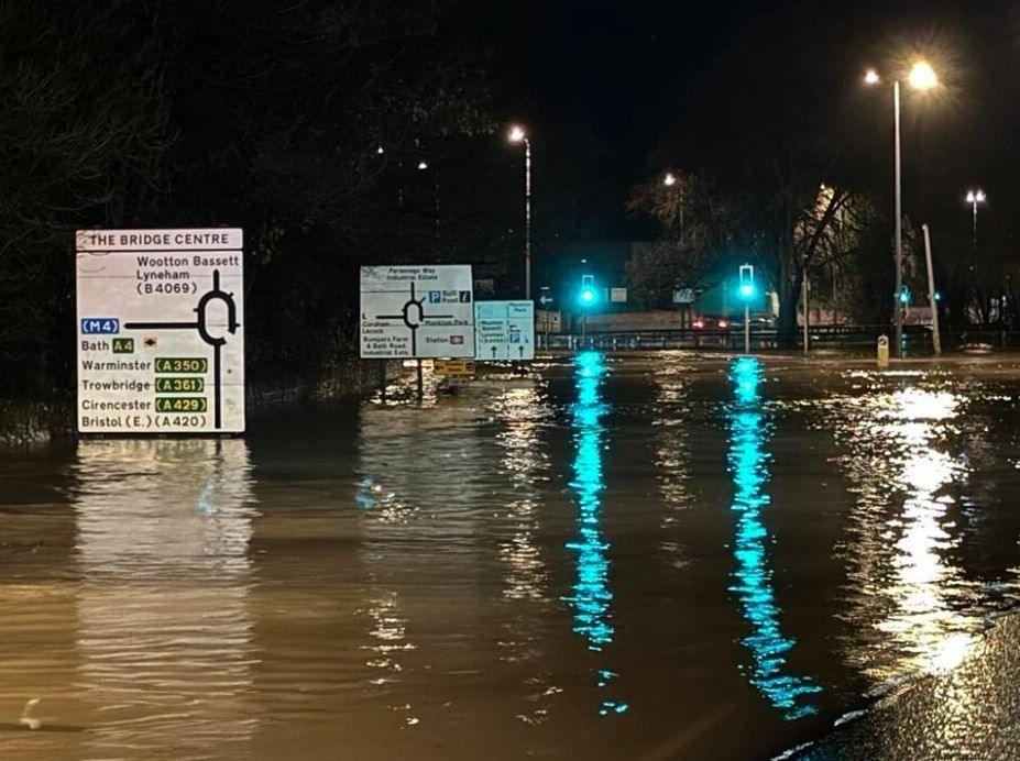 Flooded road with street signs in the background