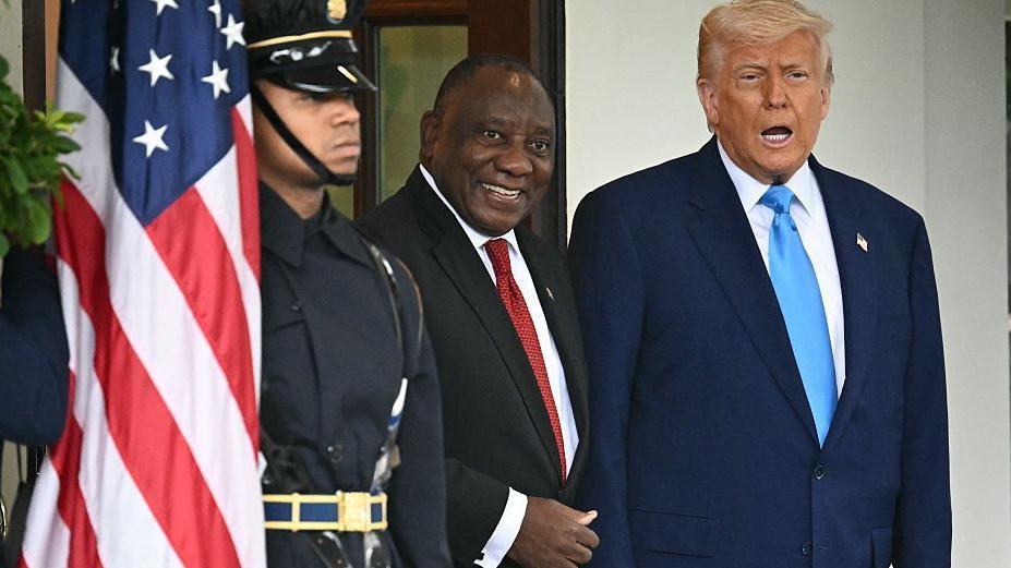 President Ramaphosa and President Trump standing side by side, next to a guard and a US flag