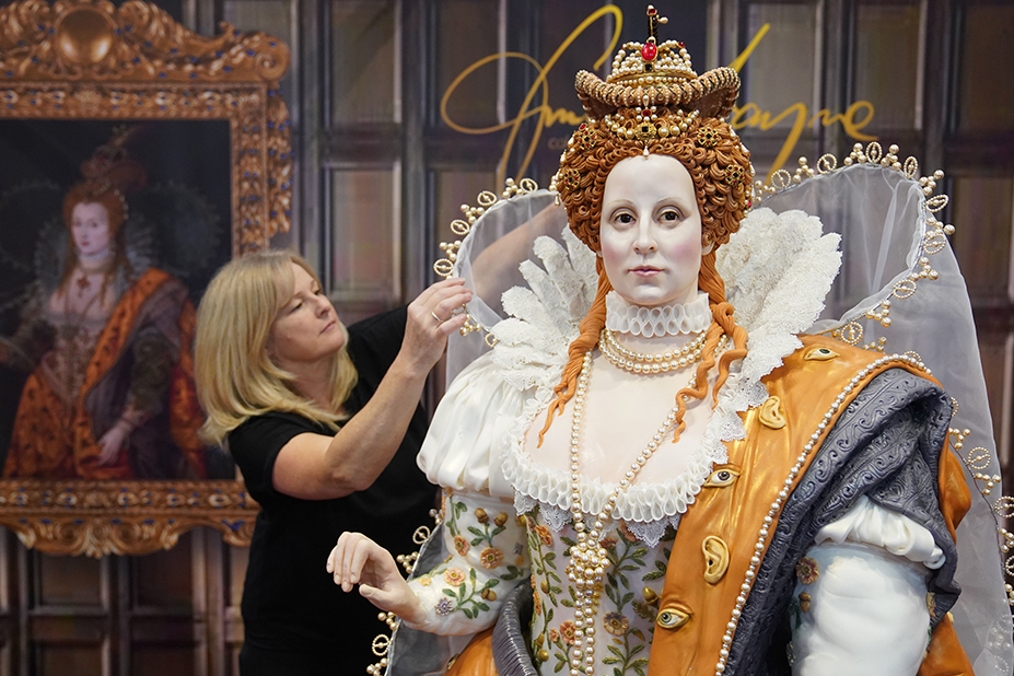 Cake artist Emma Jayne adjusting the outfit on her edible life-sized version of Queen Elizabeth I. The Tudor queen is wearing a crown and jewels as well as an finely embroidered dress.