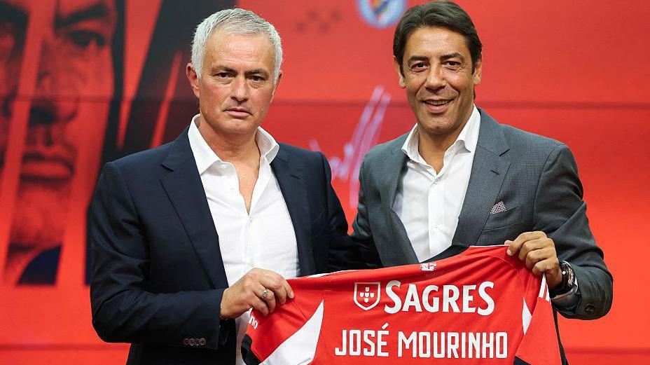 Jose Mourinho (left) and Benfica president Rui Costa (right) hold up a Benfica shirt with Mourinho's name on the back at his unveiling as manager