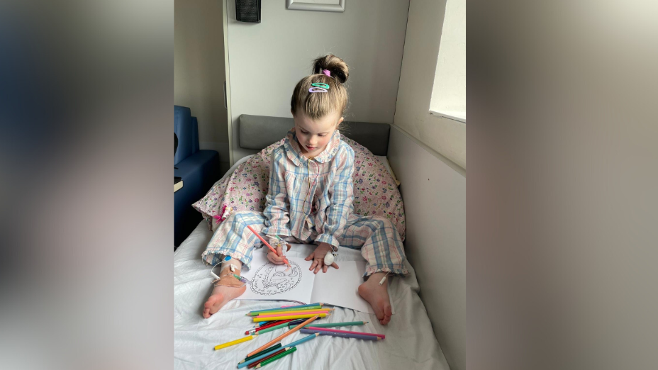 Isobel is on bed colouring. An array of different coloured pencils are on her bed. She's wearing pyjamas 