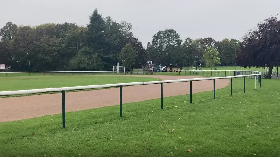 Braywick Park - a running track with a fence around it and a play area in the distance