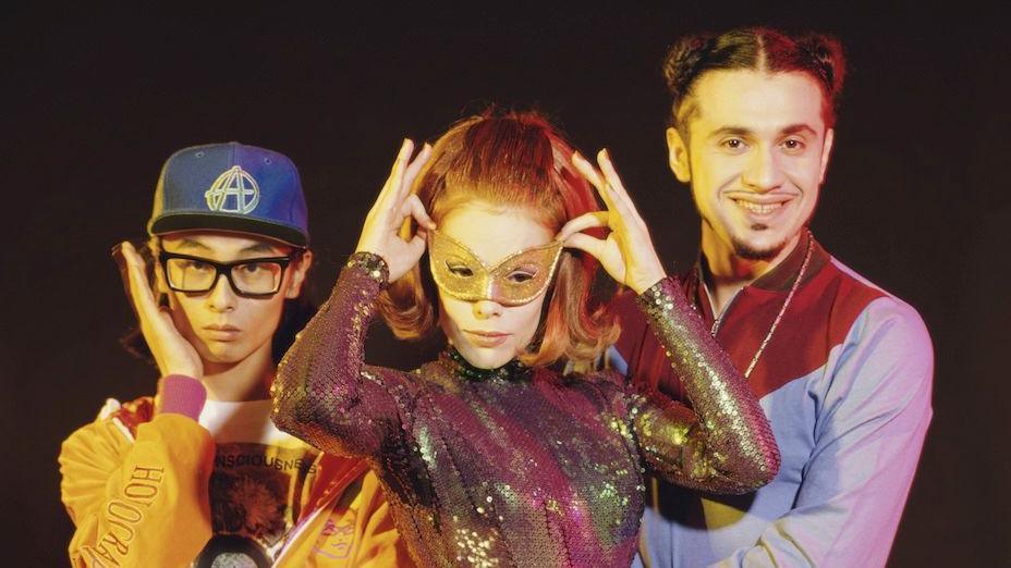 The pop group Deee-Lite - frontwoman Lady Miss Kier is in the middle and is waring a pinky-brown sequined top and a gold eyemask.