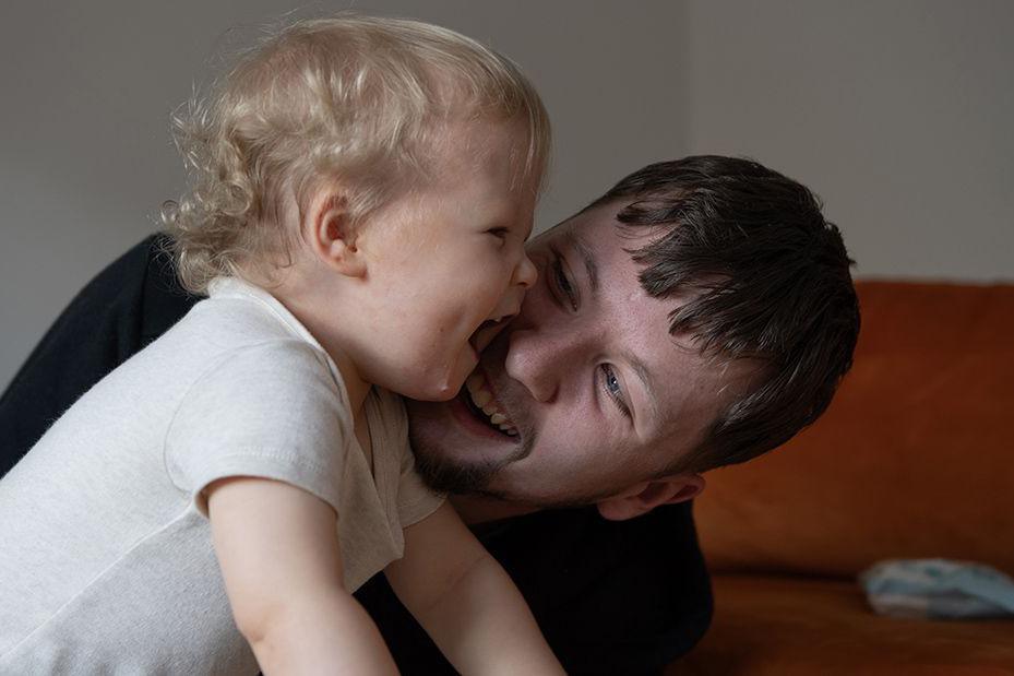 Callum Fay has his face close to his young son Archie's face and is smiling while Archie laughs.