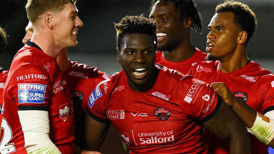 Justin Sangare celebrates scoring a try for Salford Red Devils