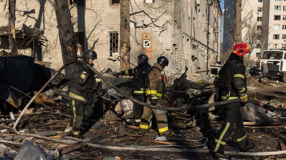 Ukrainian emergency personnel work at the scene of a missile attack 