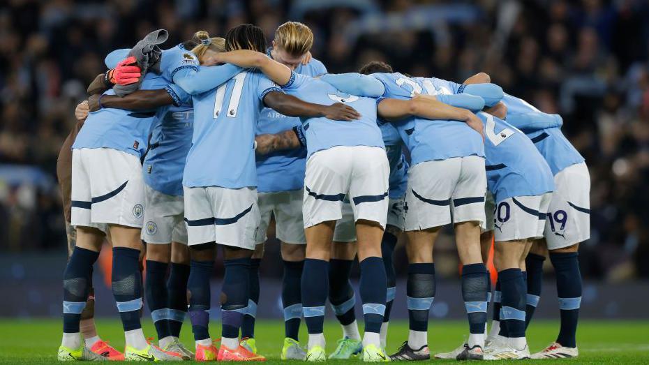Manchester City players huddle earlier  their Premier League fixture against Manchester United successful  December