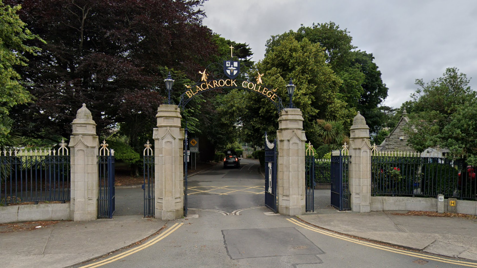 The gates of Blackrock College in south Dublin, with and arch showing the college crest and sign in black and gold lettering