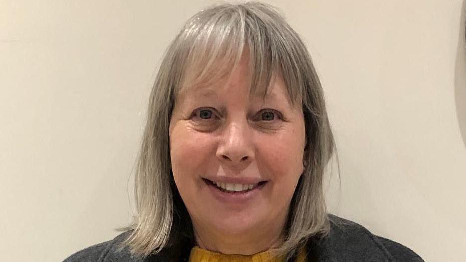 Carol Hyatt smiling. She has grey hair that is styled into a bob with a fringe