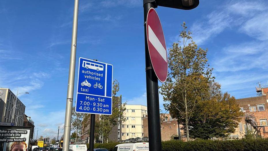 Close up of the bus lane sign mounted on a black pole in dark blue with white lettering saying "authorised vehicles".