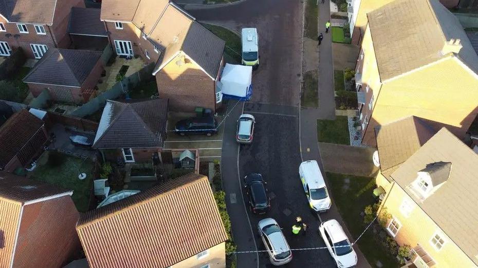 An aerial of Allan Bedford Crescent in Costessey near Norwich. A number of vehicles can be seen parked down the road. 