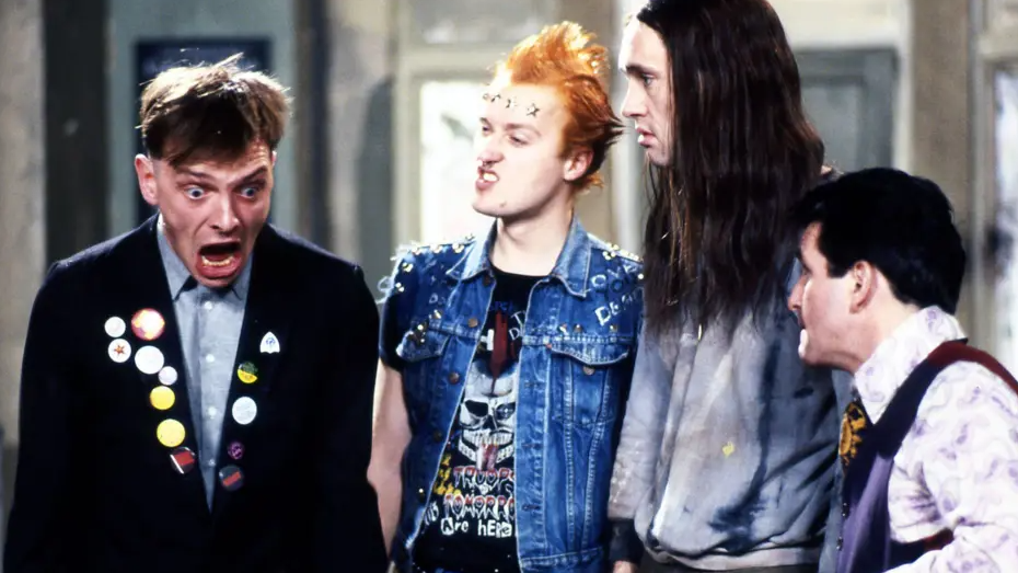 The full cast of The Young Ones are captured during a scene.