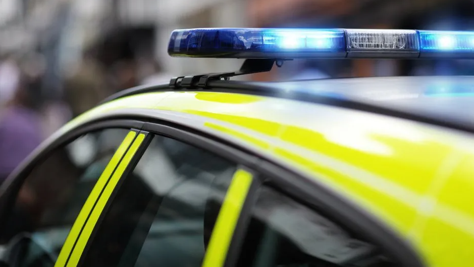 A police car with a blue siren on the roof