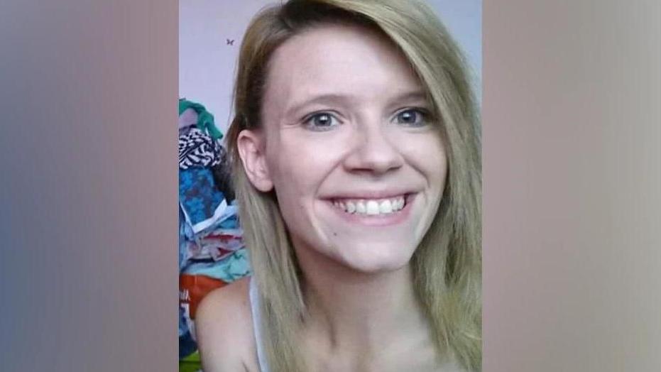 A woman with shoulder length blonde hair smiles widely at the camera.