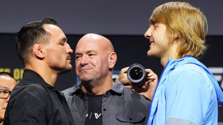 Michael Chandler faces off with a smiling Paddy Pimblett at a news conference