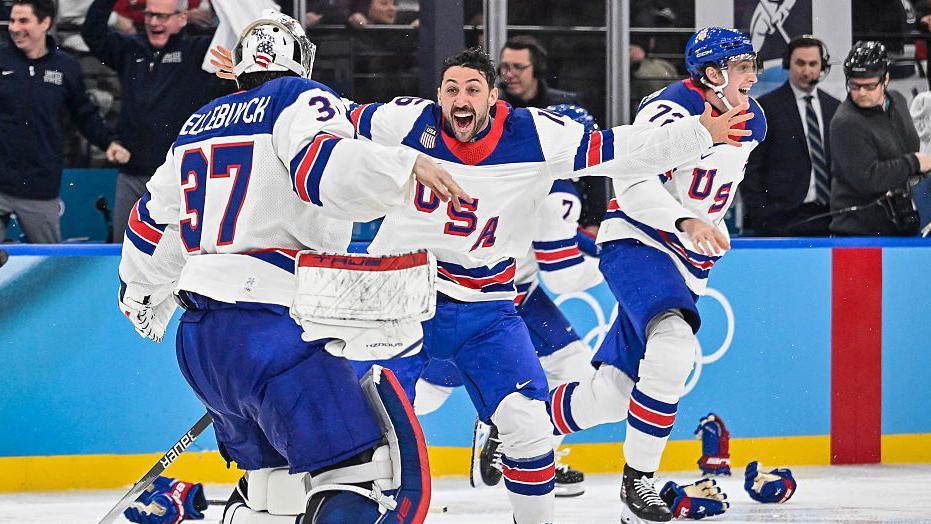 USA players celebrate winning the men's gold medal ice hockey match between Canada and USA 