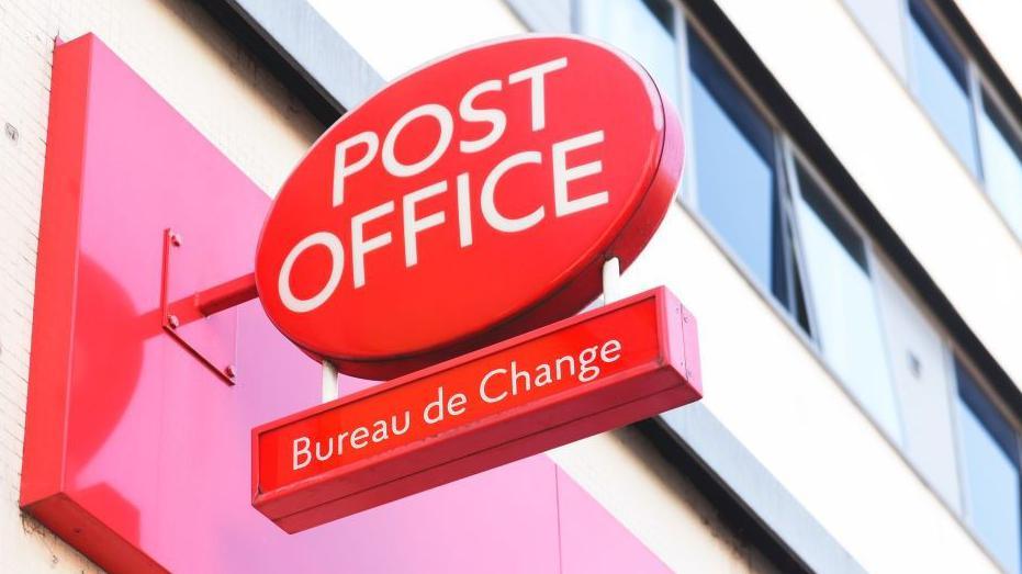 Red Post Office sign, with Bureau de Change on a smaller sign hanging underneath it