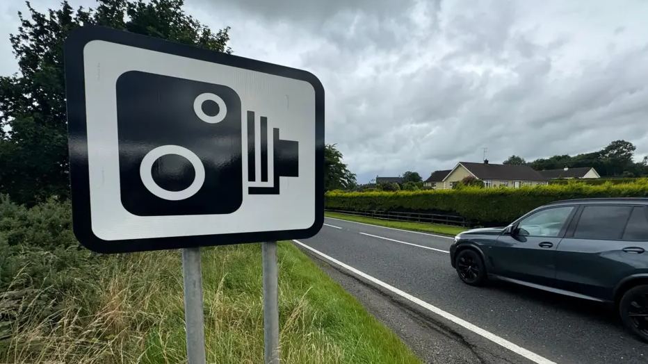 car drives past a speed camera road sign