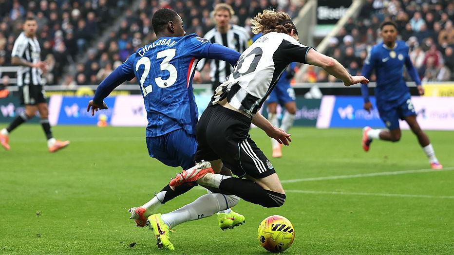Anthony Gordon of Newcastle United is challenged in the box by Chelsea defender Trevoh Chalobah
