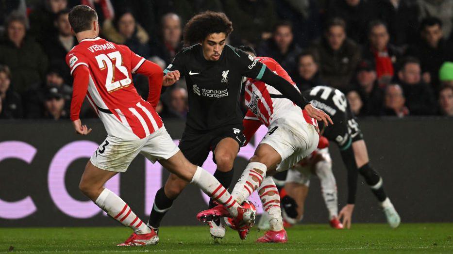 Liverpool striker Jayden Danns attempts to dribble the ball between two PSV Eindhoven defenders during last week's Champions League match.