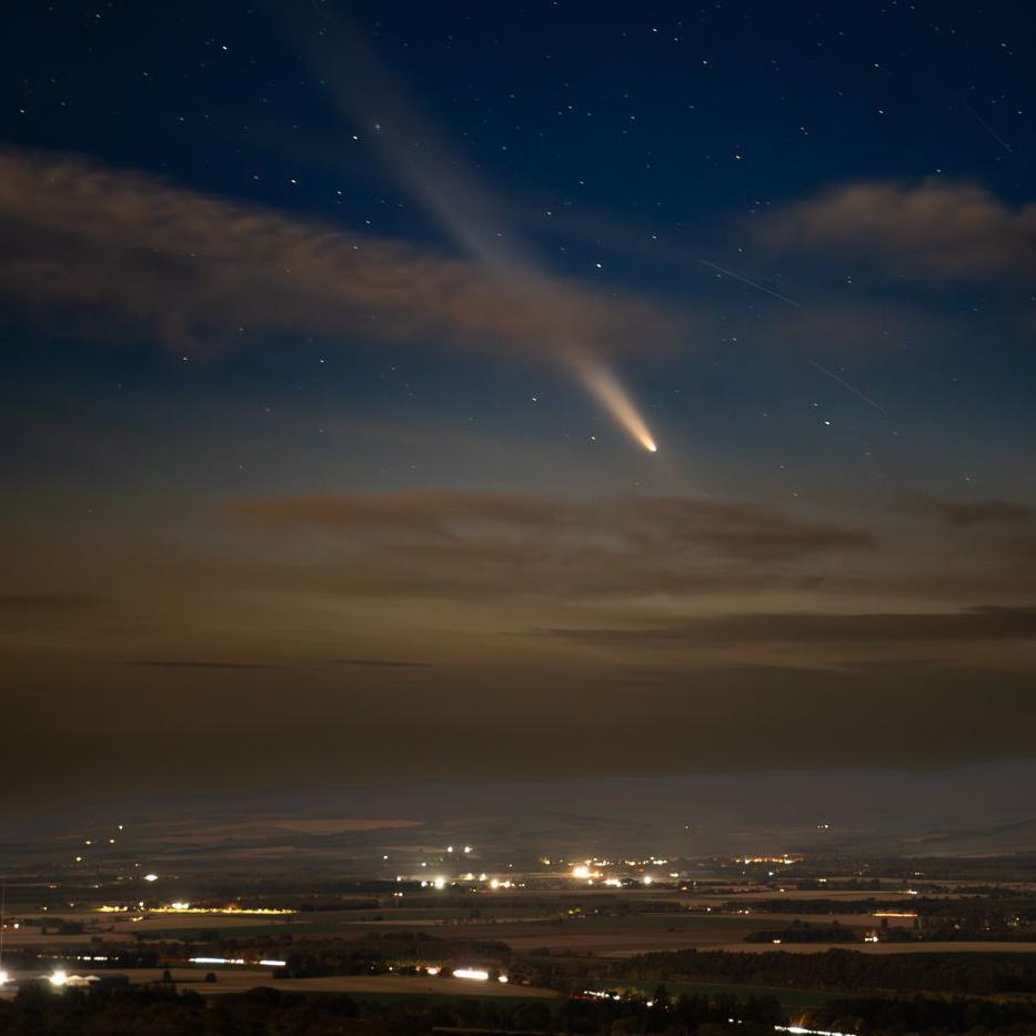 Comet A3 above lights in a rural landscape called Howe of the Mearns.