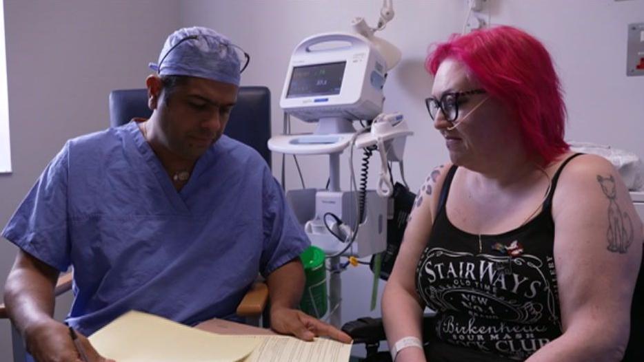 Dr Singhal dressed in blue scrubs sitting next to Pinky Jolley 