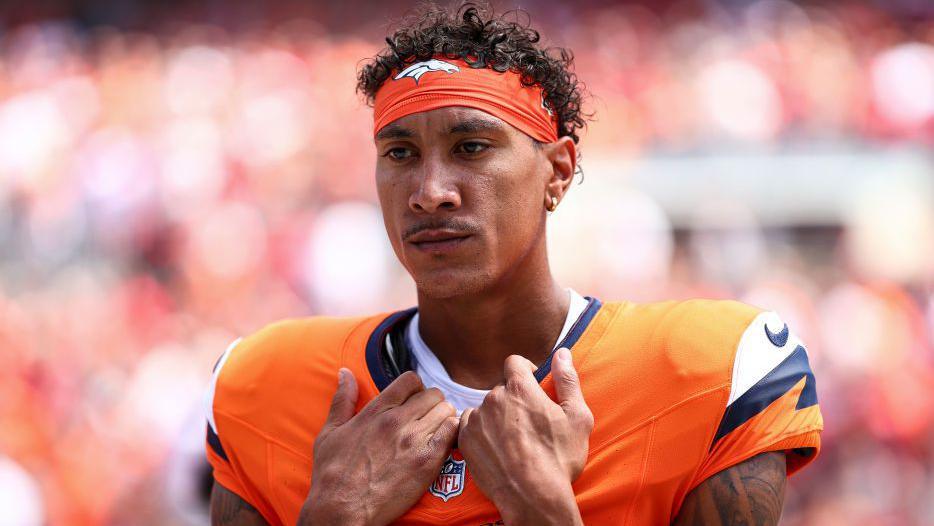 Josh Reynolds holds the collar of his Denver Broncos shirt during the national anthem prior to their game against the Tampa Bay Buccaneers