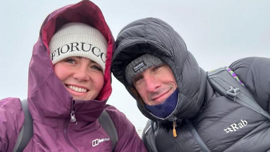 Robyn Foster and Jay Taylor in coats with their hoods up.