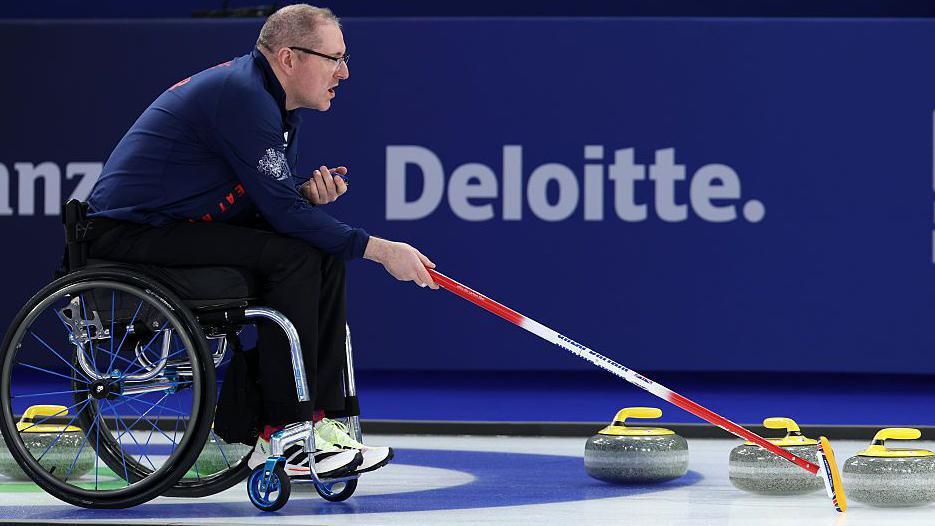 GB wheelchair curling skip Hugh Nibloe shows his team where to aim for on the ice