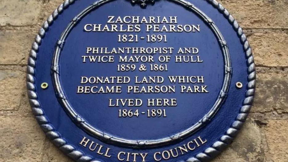 A blue plaque on a brick house wall. It has gold letters which read: Zachariah Charles Pearson 1821-1891. Philanthropist and twice Mayor of Hull 1859 and 1861 donated land which became Pearson Park. Lived here 1864 to 1891.