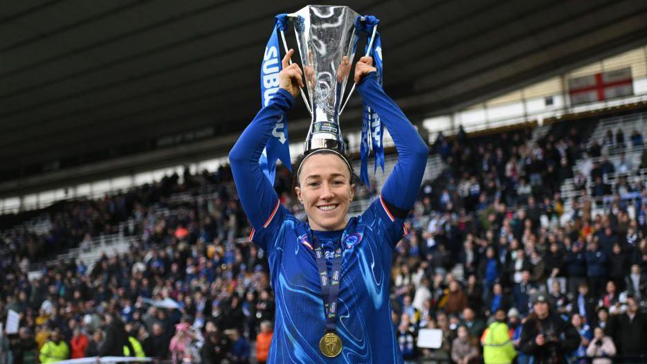 Lucy Bronze of Chelsea celebrates with the trophy following her team's victory in the Subway Women's League Cup Final match between Chelsea and Manchester City