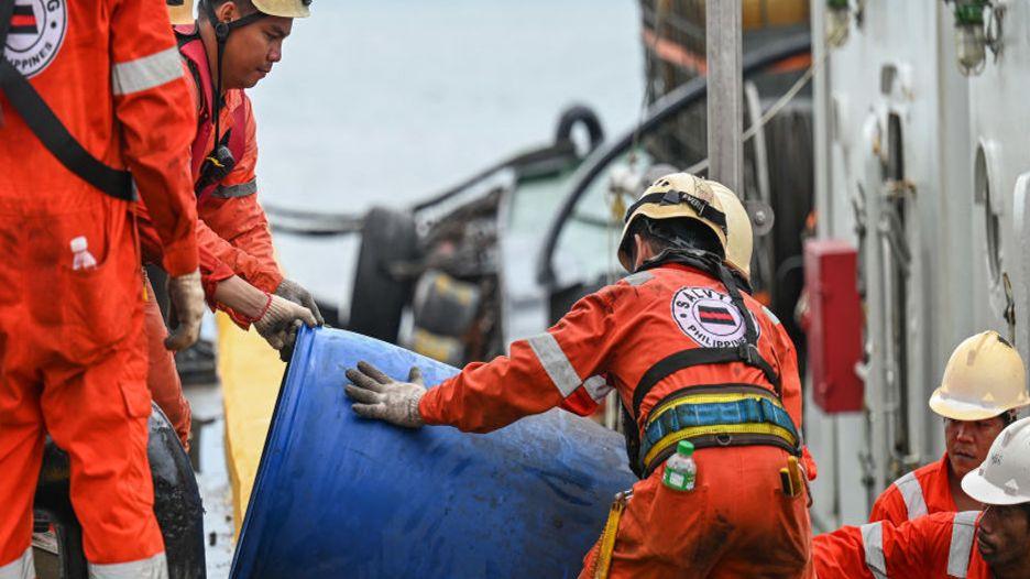 Crew of a private company loads a barrel of oil spill dispersant to be used in the oil spill response,