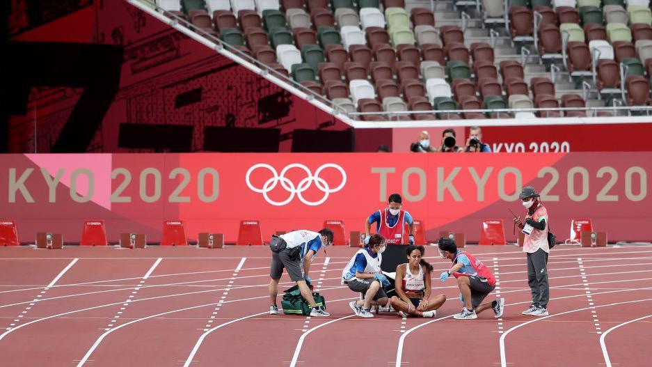 Katarina Johnson-Thompson receives medical attention after suffering an injury at Tokyo 2020