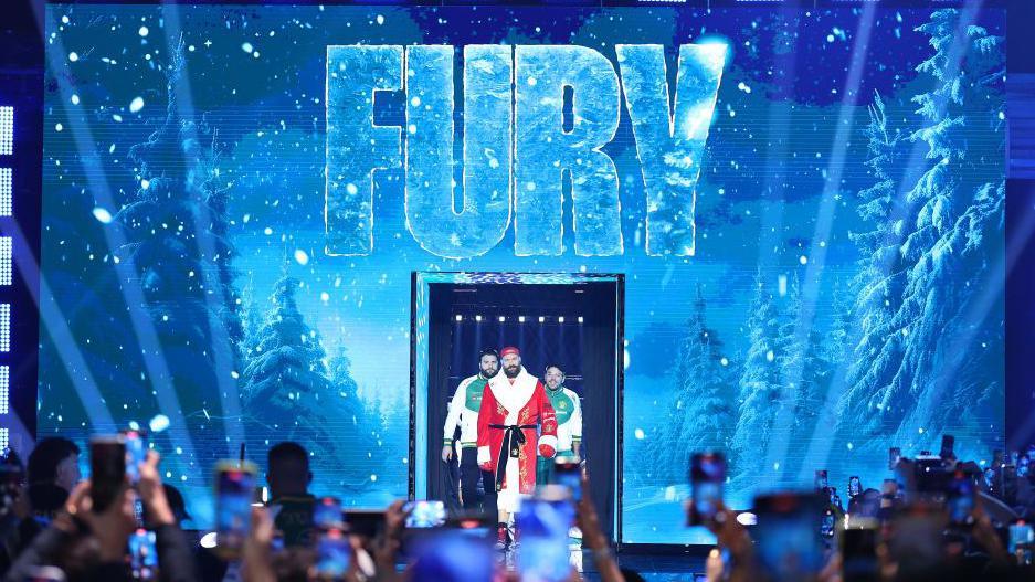 Tyson Fury enters the ring dressed as Santa