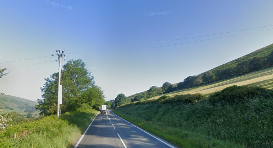 A stretch of the A470 between Rhayader and Llangurig, with trees and grassy hills on either side